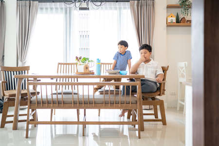 In the living area, brothers are eating french fries together.の写真素材