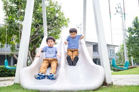 On the playground, two brothers are enjoying each other's company.の写真素材