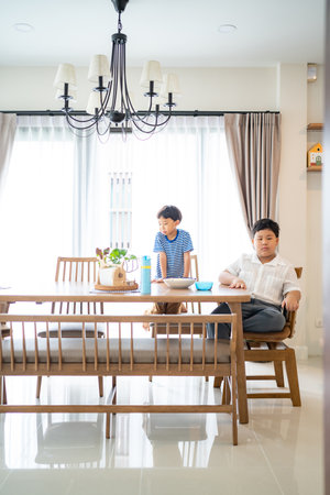 In the living area, brothers are eating french fries together.の写真素材