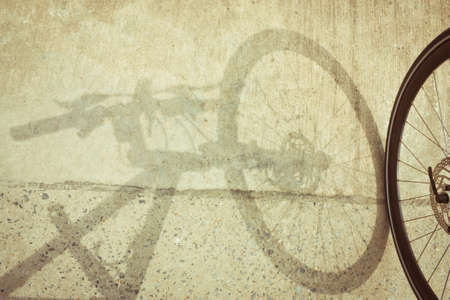 Bicycle wheel and shadow on grunge blackgroundの写真素材