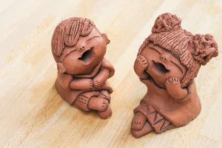 Clay pottery  dolls on wood backgroundの写真素材