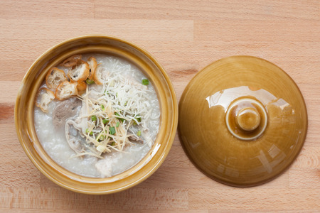 Traditional porridge rice in ceramic bowl on wood background