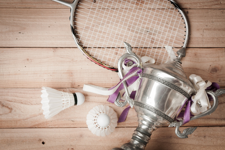 Shuttlecocks, racket and badminton trophy on wood backgroundの写真素材