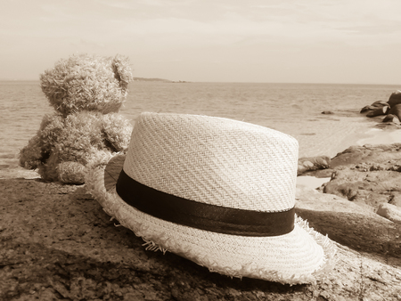 Teddy bear sitting on rock with sepia imageの写真素材