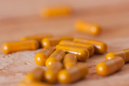 Herbal medicine in capsules on wood backgroundの写真素材