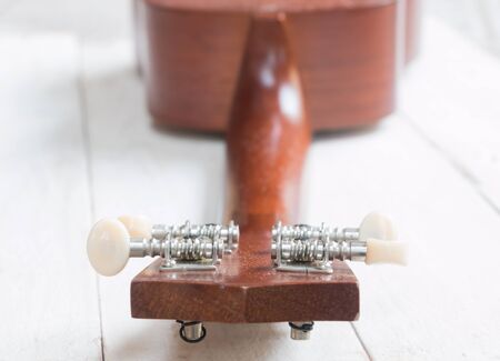 Headstock of ukulele hawaiian guitar on wood background