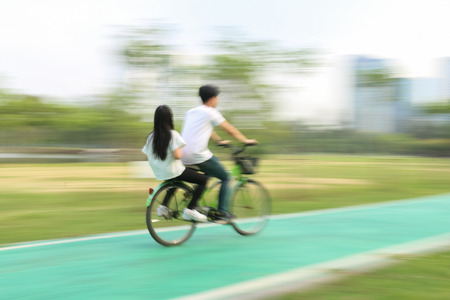 Bicycle rider on a bicycle path in park , motion blurの写真素材