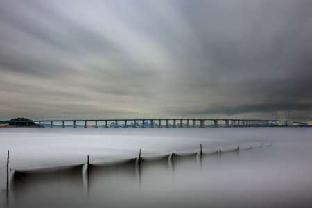Dramatic long exposure of a bridge on the Daugava river in Riga, Latvia.の写真素材