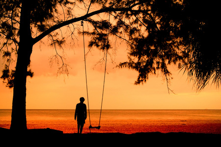 Silhouette of unidentified girl on beach with sunset light.の写真素材