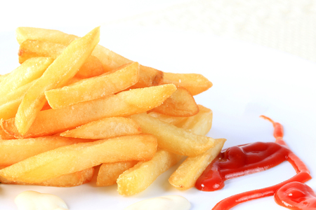 French fries with tomato sauce and mayonnaise on white background.