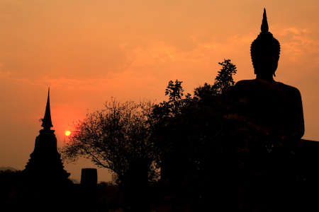 Silhouette of ancient stupa and buddha statue in ancient city, Sukhothai, Thailand.の写真素材