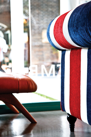 Side of red white blue strip sofa in living room.
