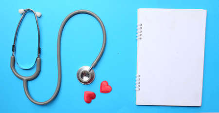 A stethoscope and a red heart are on the green doctor table.health and medical conceptsの写真素材