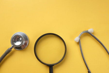 flat lay  and copy space stethoscope and Magnifying glass on a yellow backgroundの写真素材