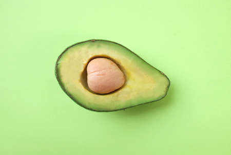 top view and flat lay.fruit Organic avocado with seed, avocado halves  on bright green background. creative summer food concept. minimal flat lay styleの写真素材