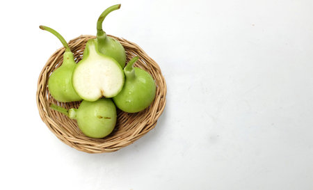 fresh raw organic green Bottle gourd , White-flowered gourd, Calabash cucumber or calabash  ( Lagenaria Siceraria) Whole with cut in half slice  in a wooden basketの写真素材