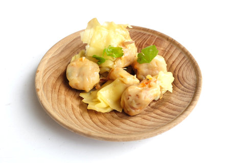 Appetizing  a Shumai 
or Chinese Steamed Dumpling,meatball dumpling with wonton skin,Steamed Pork Dumpling  served in a wooden dish with soy sauce isolated on a white backdropの写真素材