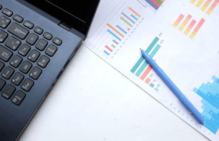 business graphs, charts, pen, and glasses ,laptop computer on table. financial development, banking account, statisticsの写真素材