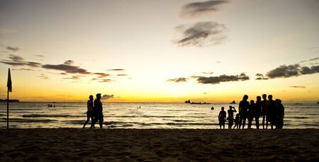 People Walking By The Beach At Sunsetの写真素材