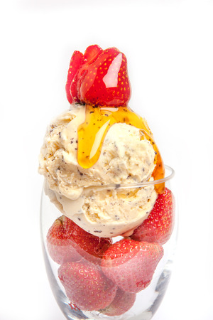 Scoop of vanilla ice cream in glass, topping with strawberry and syrupの写真素材