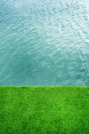 green grass with waving water surface of the sea with copy spaceの写真素材