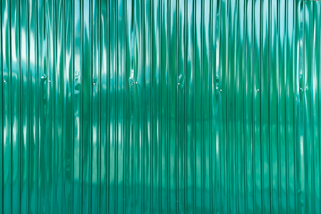 green corrugated Iron fence with hilight reflectionの写真素材