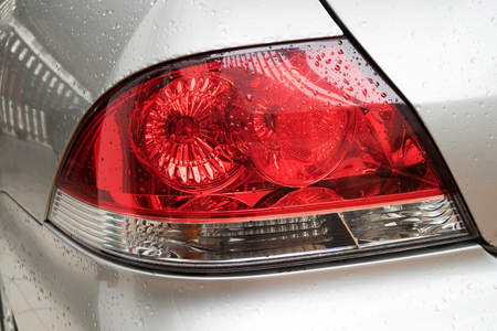 close up rain drops on car light after rainingの写真素材