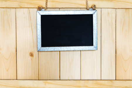 aluminum frame chalkboard hanging on wooden wallの写真素材