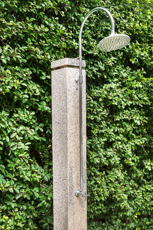 outdoor shower sprinkler on green tree ficus annulata backgroundの写真素材