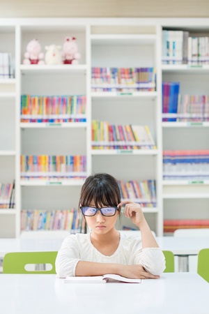 an unhappy girl feeling bored or upset while reading bookの写真素材