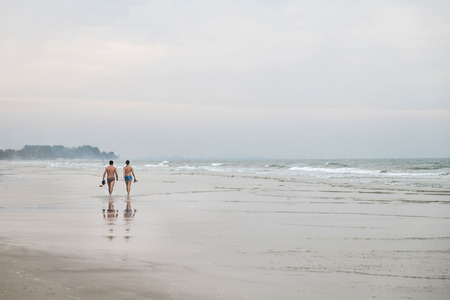 lover in swimming suit walking along the beachの写真素材
