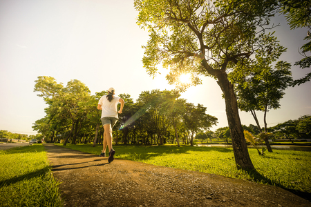 asian young woman running in park in the morningの写真素材