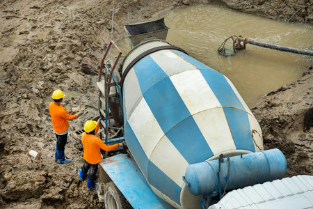 builder worker with tube from truck mounted concrete pumpの写真素材