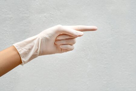 cropped hand of person pointing against wall white background - concept âWay outâ or âsuggestionâの写真素材
