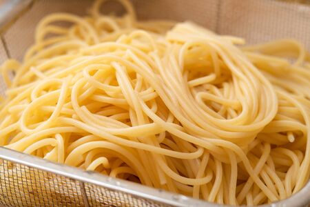spaghetti noodle in stainless steel bowl isolated on white backgroundの写真素材