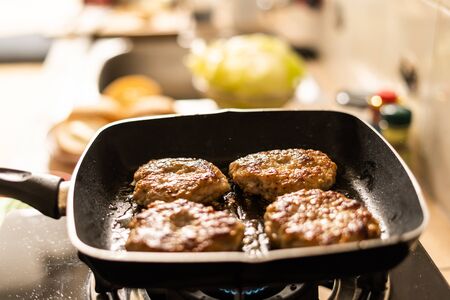 Beef cutlets in a frying pan On the gas stove in the kitchenの写真素材