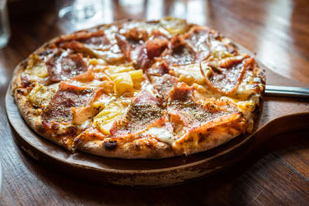 traditional italian pizza with ham and mushrooms on wooden tableの写真素材