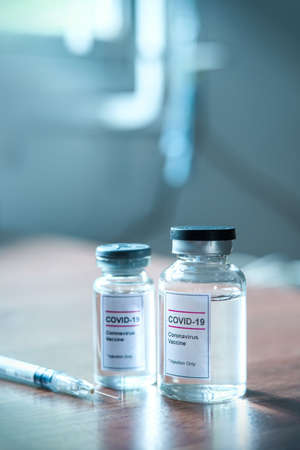 Coronavirus, COVID-19 Vaccine Vials and Syringe On doctor tableの写真素材