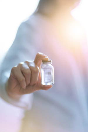 injection vaccine vaccination medicine flu woman doctor - covid 19 corona virus ampoule vaccine cure in doctor scientist hand with light to the vaccine bottle concept to new hopeの写真素材
