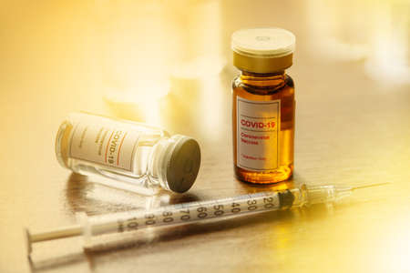 Coronavirus, COVID-19 Vaccine Vials and Syringe on doctor table