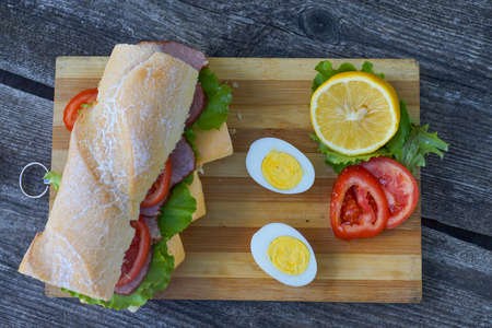 big tasty sandwich with tomato lettuce with soap and ham on white background