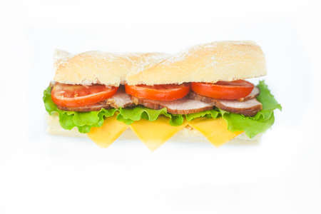 big tasty sandwich with tomato lettuce with soap and ham on the board. next to it is juice with ice in a glass. white backgroundの写真素材