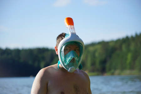 guy in full face snorkeling mask stands in water