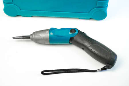 Electric screwdriver lies next to the drawer with a set of screwdriversの写真素材