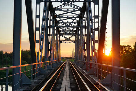 Railway bridge over the river in the evening at sunsetの写真素材