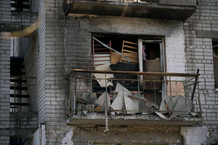 Ruined house without windows. Balcony of a destroyed house. Burnt house after shelling during the...