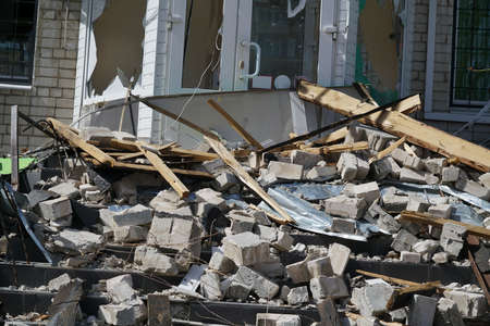 pieces and fragments of walls lie near the house after the explosion of a shell in Ukraine