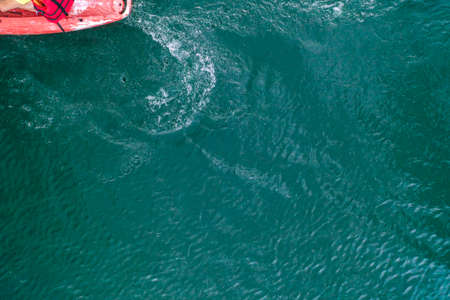 Red kayak floats on water, rear side viewの写真素材