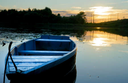 old wooden boats stand on the river in the eveningの写真素材