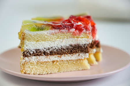 a piece of puff pastry cake with strawberries and kiwi is on a plateの写真素材